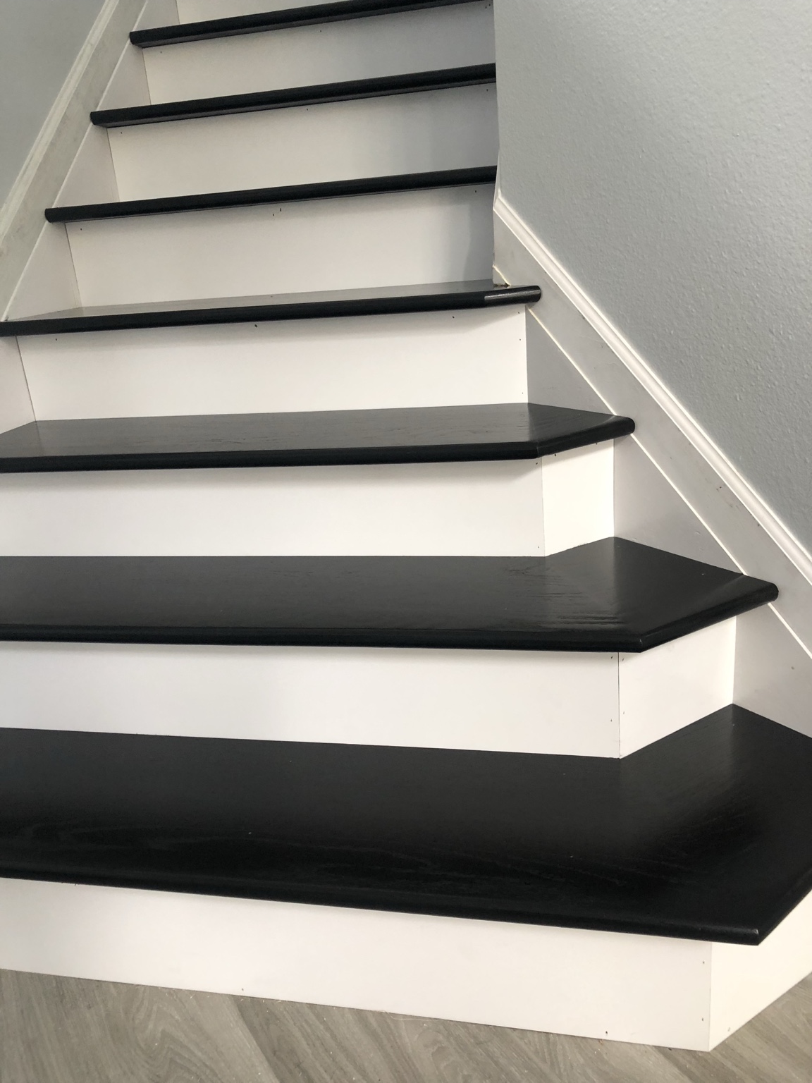 Detail of black treads and white risers on the lower stair flight