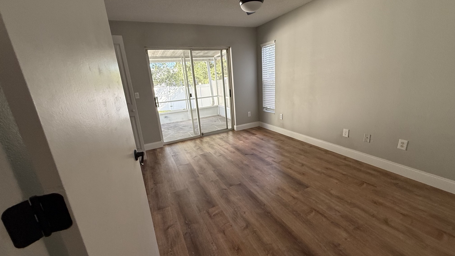 Renovated bedroom with wood-look flooring and white baseboards