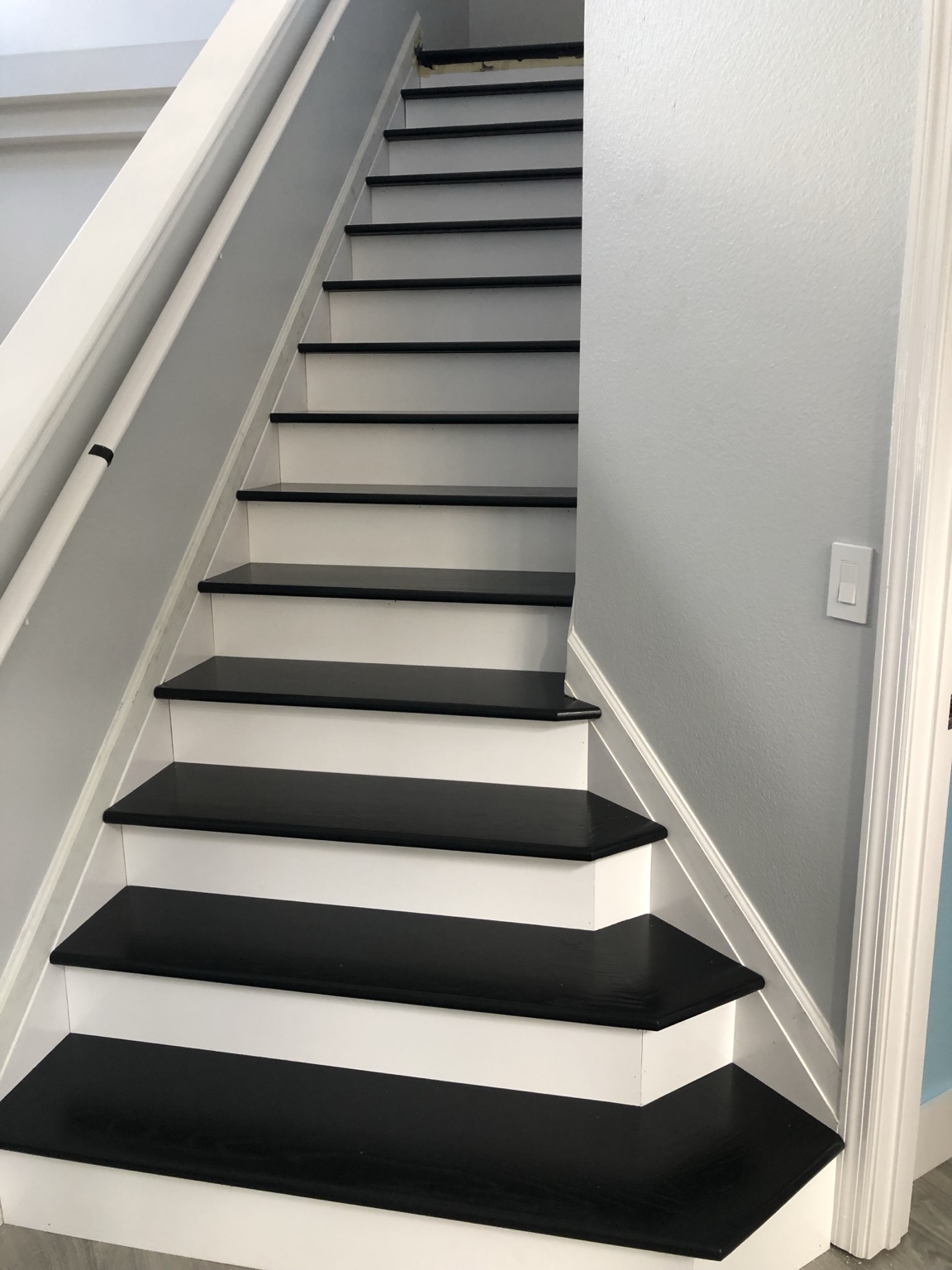 Staircase with black treads, white risers and gray walls